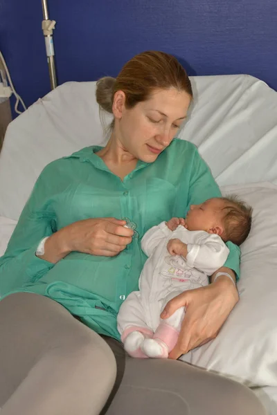 Uma mãe olha para seu bebê recém-nascido — Fotografia de Stock