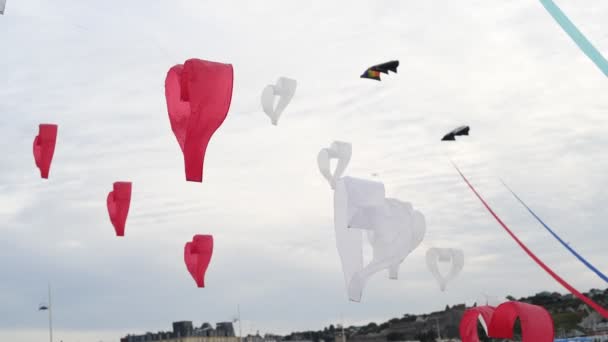 Rood en wit vliegers harten vliegen in de wind — Stockvideo