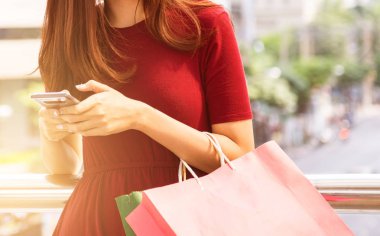 cep telefonu kullaranarak alışveriş çantası, Satılık, tüketim ve insanlar kavramı ile genç kadınlar. moda sesi.