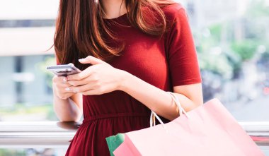 cep telefonu kullaranarak alışveriş çantası, Satılık, tüketim ve insanlar kavramı ile genç kadınlar. moda sesi.