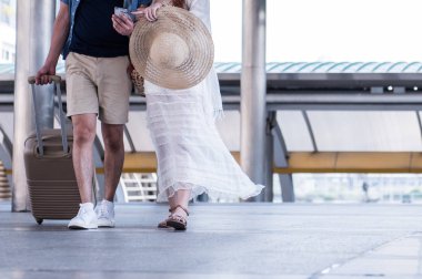 Mutlu çift cep telefonu ve yaşayan yürüme kullanmak, insanların yaz tatil kavramı içinde seyahat.