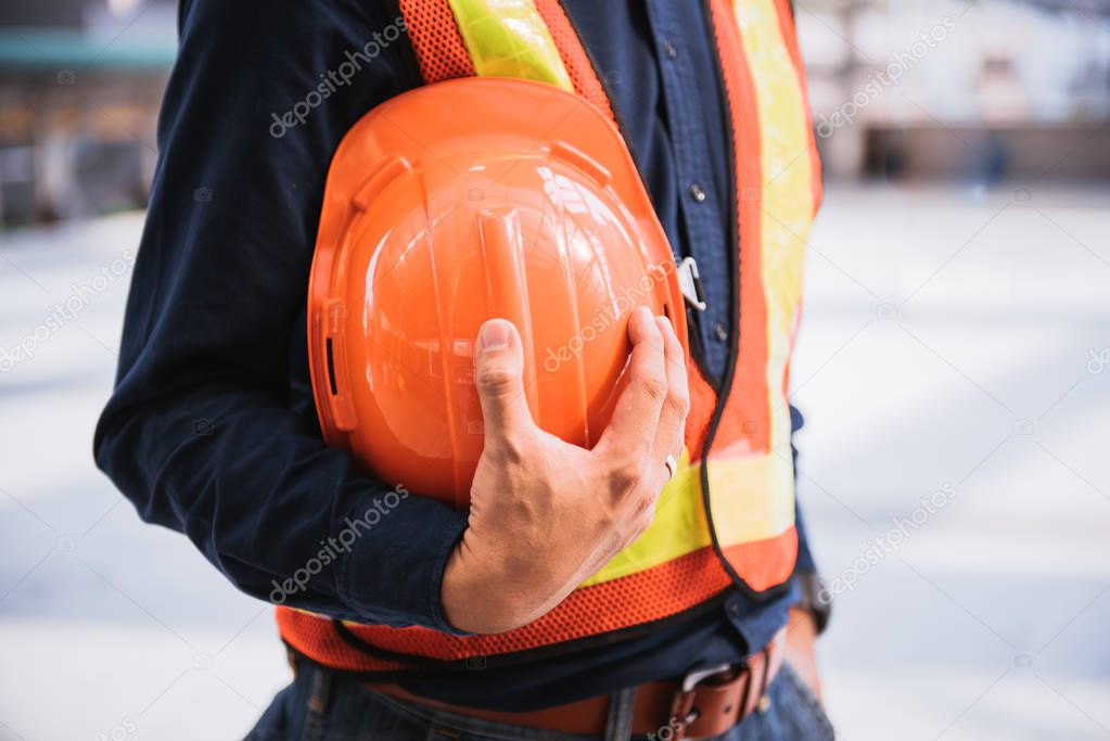engineer holding orange helmet for workers security on buildings and construction, engineering construction industry concept.