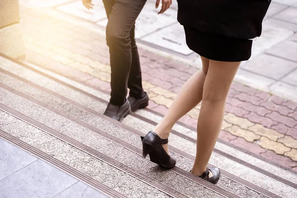 Business people walking on stairs outdoors.