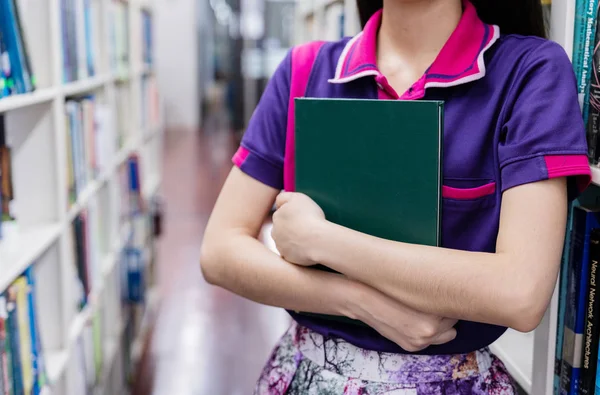 women Choosing and hug book in library room, education concept.