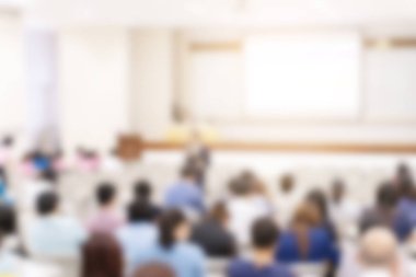 Konferans salonu veya seminer odasındaki iş adamlarının geçmişi bulanık.