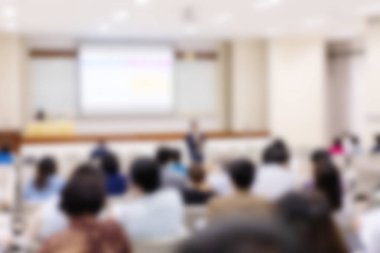 Konferans salonu veya seminer odasındaki iş adamlarının geçmişi bulanık.