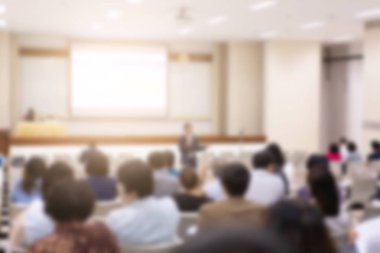 Konferans salonu veya seminer odasındaki iş adamlarının geçmişi bulanık.