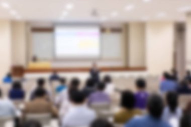 Konferans salonu veya seminer odasındaki iş adamlarının geçmişi bulanık.