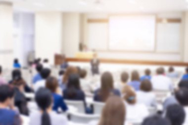 Konferans salonu veya seminer odasındaki iş adamlarının geçmişi bulanık.
