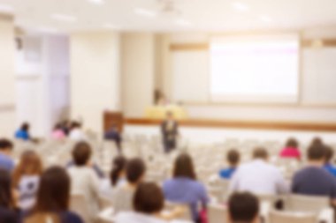 Konferans salonu veya seminer odasındaki iş adamlarının geçmişi bulanık.