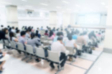 Konferans salonu veya seminer odasındaki iş adamlarının geçmişi bulanık.