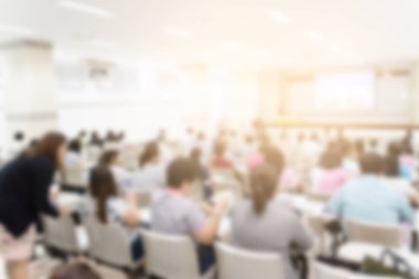 Konferans salonu veya seminer odasındaki iş adamlarının geçmişi bulanık.