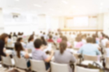 Konferans salonu veya seminer odasındaki iş adamlarının geçmişi bulanık.