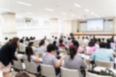 Konferans salonu veya seminer odasındaki iş adamlarının geçmişi bulanık.