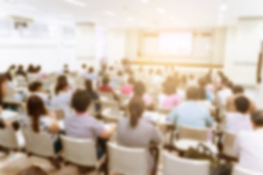 Konferans salonu veya seminer odasındaki iş adamlarının geçmişi bulanık.