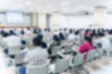 Konferans salonu veya seminer odasındaki iş adamlarının geçmişi bulanık.