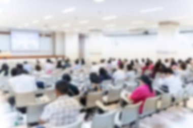 Konferans salonu veya seminer odasındaki iş adamlarının geçmişi bulanık.