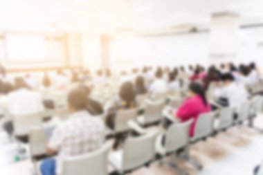 Konferans salonu veya seminer odasındaki iş adamlarının geçmişi bulanık.