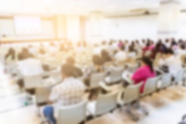 Konferans salonu veya seminer odasındaki iş adamlarının geçmişi bulanık.