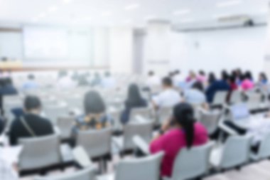 Konferans salonu veya seminer odasındaki iş adamlarının geçmişi bulanık.