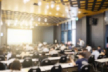 Konferans salonu veya seminer odasındaki iş adamlarının geçmişi bulanık.
