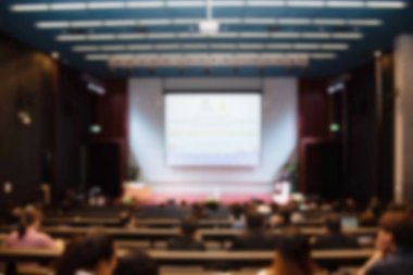 Konferans salonu veya seminer odasındaki iş adamlarının geçmişi bulanık.