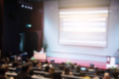 Konferans salonu veya seminer odasındaki iş adamlarının geçmişi bulanık.