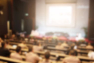 Konferans salonu veya seminer odasındaki iş adamlarının geçmişi bulanık.