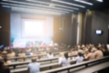 Konferans salonu veya seminer odasındaki iş adamlarının geçmişi bulanık.