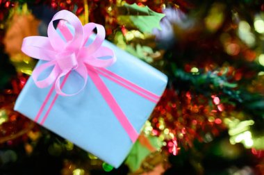 Bulanık arkaplanda Noel ağacıyla süslenmiş hediye kutuları.