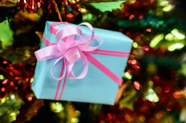 Bulanık arkaplanda Noel ağacıyla süslenmiş hediye kutuları.