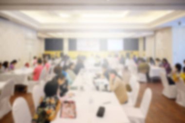 Konferans salonu veya seminer odasındaki iş adamlarının geçmişi bulanık.