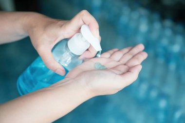 Coronavirüs ya da covid-19 için karantinada çalışan iş kadını dezenfektan jeliyle ellerini temizliyor..