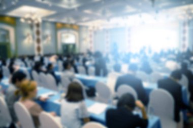 Konferans salonu veya seminer odasındaki iş adamlarının geçmişi bulanık.