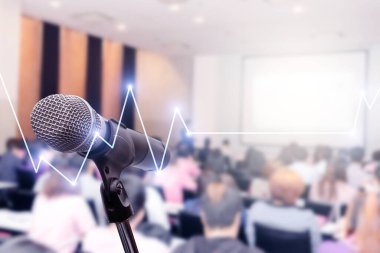 Bulanık iş adamları forumunda mikrofon toplantı ya da konferans eğitim eğitim koçluk odası konsepti üzerinde borsa ya da ön plan ticaret grafiği, bulanık arkaplan.