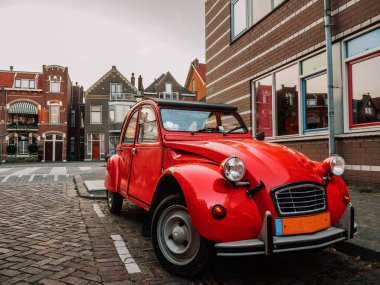 Hollandalı şehir Vlaardinger şafak vakti (Rotterdam, Hollanda, Hollanda, Arnavut kaldırımlı sokakta güzel retro kırmızı araba)