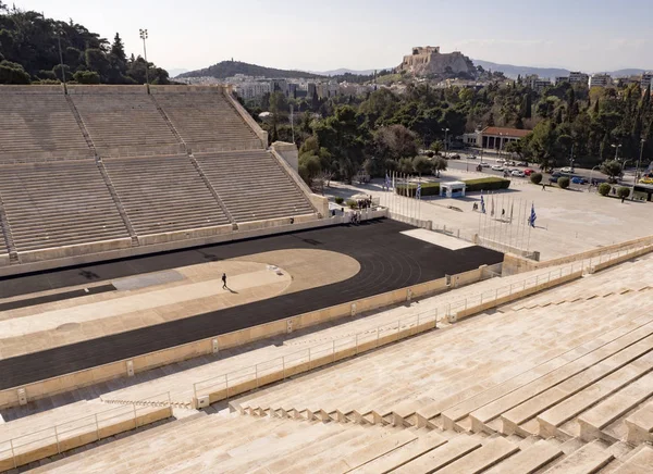 View of the ancient stadium of the first Olympic Games in white marble - Panathenaic Stadium - overlooking the Acropolis and the Parthenon in the city of Athens, Greece