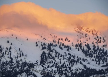 Dağlar ve güneşli bir bulutlar Evia Adası (Euboea) Ege Denizi'nde arka plan üzerinde kar ile orman