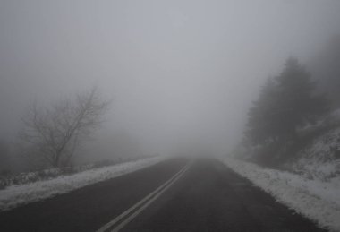 Dağ yolu, sis, bulutlar ve kar yağışı dağlarda Dirfis: Evia, Yunanistan adada ormanda