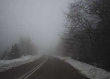 Dağ yolu, sis, bulutlar ve kar yağışı dağlarda Dirfis: Evia, Yunanistan adada ormanda