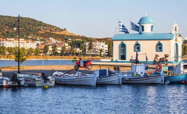 青と白の色と水辺の小さな美しいギリシャの教会は エビア島の青い空に対して晴れた日にウォーターフロントに漁船 ギリシャ — ストック写真