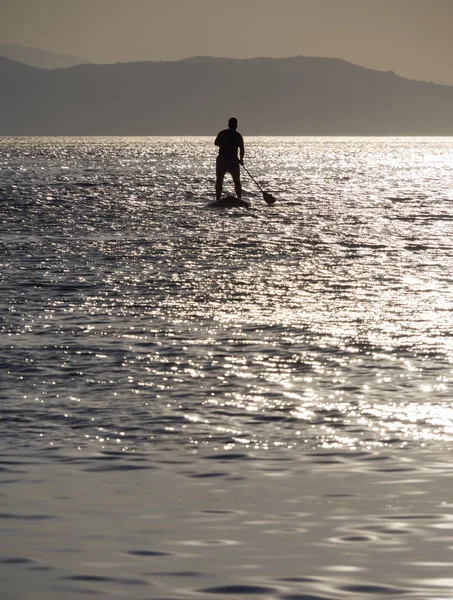 SUP Surfing at sunset in the Aegean Sea in Greece