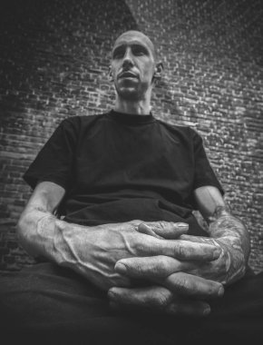 Kel adam acımasız bir görünüme sahip ve silah siyah ve beyaz ön planda dövmeli portre