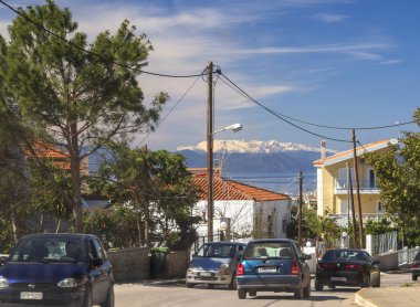 Evia island, Yunanistan. 11 Mart 2019: karda ufukta şehrin araç, deniz ve Parnassos Dağları ile sokak görünümü