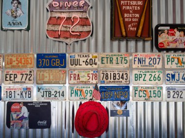 Yunanistan, Haziran 2020: Yunanistan 'da bir motosiklet kafesinde farklı eyaletlerden alınmış bir araba plakası, poster resimleri ve kırmızı kovboy şapkası koleksiyonu