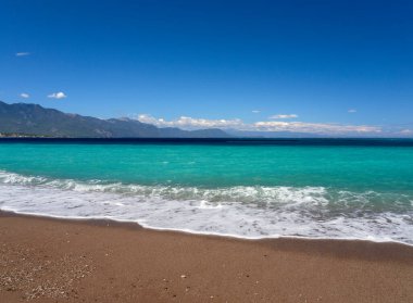 Korint Körfezi 'ndeki Psatha sahilinde güzel köpüklü dalgalar ve Yunanistan' daki İyon Denizi