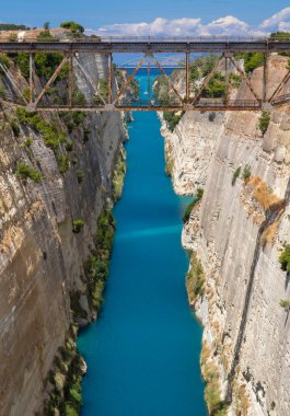 Yunanistan 'ın Mora kentindeki güneşli bir günde Corinth Kanalı' ndan geçen tekne ve yatların köprüden görünüşü