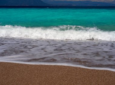 Korint Körfezi 'ndeki Psatha sahilinde güzel köpüklü dalgalar ve Yunanistan' daki İyon Denizi