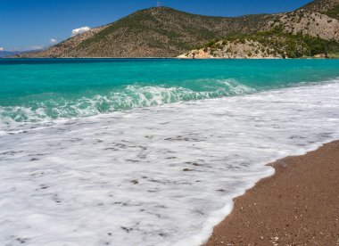 Korint Körfezi 'ndeki Psatha sahilinde güzel köpüklü dalgalar ve Yunanistan' daki İyon Denizi