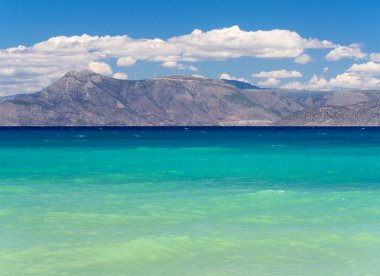 Korint Körfezi 'ndeki İyon Denizi Yunanistan' da yel değirmenleri ve bulutlu dağların arka planına karşı